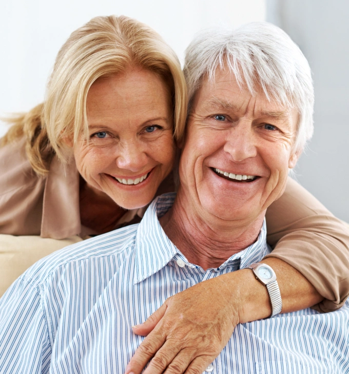 Smiling mature couple posing together in professional portrait for dental practice website.